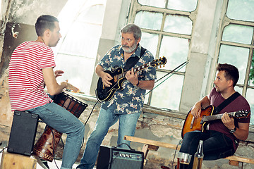 Image showing Repetition of rock music band. Electric guitar player and drummer behind the drum set.