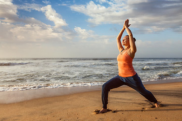 Image showing Woman doing yoga asana Virabhadrasana 1 Warrior Pose on beach on