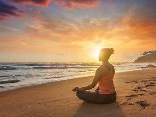 Image showing Young sporty fit woman doing yoga oudoors at beach