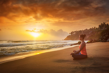 Image showing Young sporty fit woman doing yoga oudoors at beach