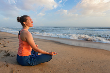 Image showing Woman doing yoga oudoors at beach - Padmasana lotus pose