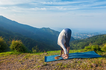 Image showing Young sporty fit woman doing yoga Sun salutation Surya Namaskar