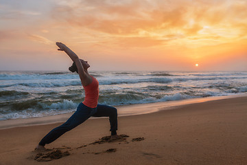 Image showing Woman doing yoga asana Virabhadrasana 1 Warrior Pose on beach on