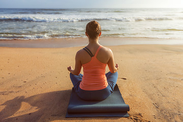 Image showing Woman doing yoga Lotus pose oudoors at beach