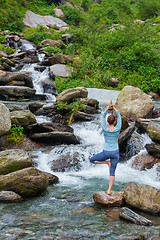 Image showing Woman in yoga asana Vrikshasana tree pose at waterfall outdoors