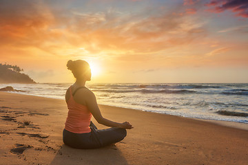 Image showing Woman doing yoga oudoors at beach - Padmasana lotus pose