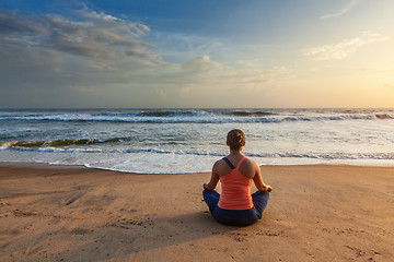 Image showing Woman doing yoga oudoors at beach - Padmasana lotus pose