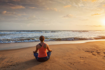Image showing Woman doing yoga Lotus pose oudoors at beach