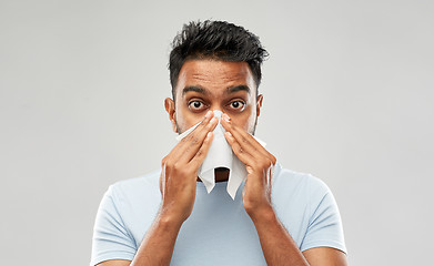 Image showing indian man with paper napkin blowing nose