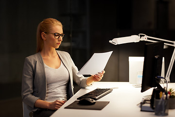 Image showing businesswoman with papers working at night office