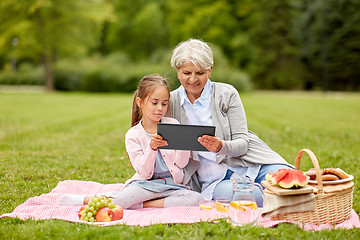 Image showing grandmother and granddaughter with tablet at park