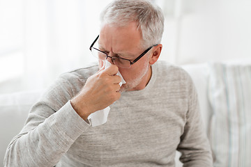 Image showing sick senior man with paper wipe blowing his nose