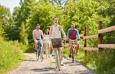 Image showing happy friends riding fixed gear bicycles in summer