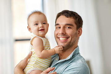 Image showing happy father holding little baby daughter at home