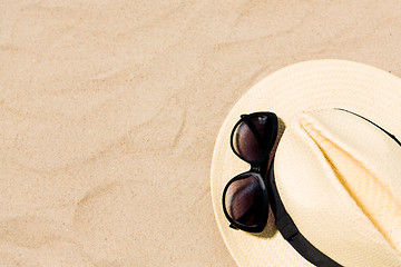 Image showing straw hat and sunglasses on beach sand