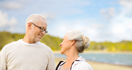 Image showing happy senior couple talking over beach background