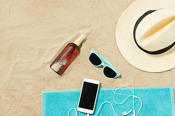 Image showing smartphone, hat, flip flops and shades on beach