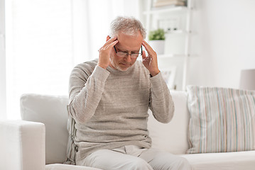 Image showing senior man suffering from headache at home