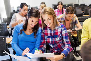 Image showing happy student girls with tests at lecture hall