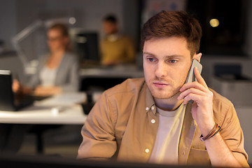 Image showing man calling on smartphone at night office