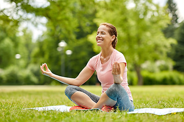 Image showing happy woman meditating in summer park