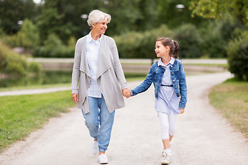 Image showing grandmother and granddaughter walking at park