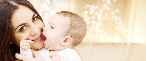 Image showing close up of mother with baby over christmas lights