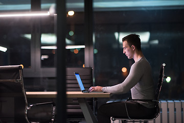 Image showing man working on laptop in dark office