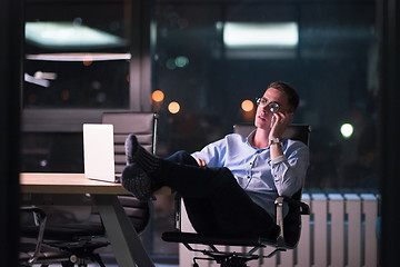 Image showing businessman using mobile phone in dark office