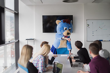 Image showing boss dresed as bear having fun with business people in trendy of