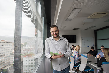 Image showing Businessman Using Tablet In Office Building by window