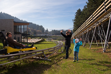 Image showing Happy family driving on alpine coaster