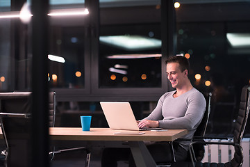 Image showing man working on laptop in dark office