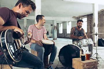 Image showing Repetition of rock music band. Electric guitar player and drummer behind the drum set.