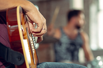 Image showing Repetition of rock music band. Electric guitar player and drummer behind the drum set.