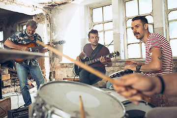 Image showing Repetition of rock music band. Electric guitar player and drummer behind the drum set.