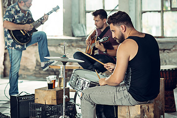 Image showing Repetition of rock music band. Electric guitar player and drummer behind the drum set.