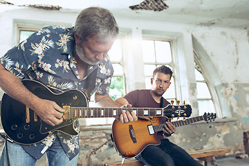 Image showing Repetition of rock music band. Electric guitar player and drummer behind the drum set.