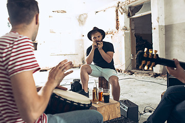 Image showing Repetition of rock music band. Electric guitar player and drummer behind the drum set.