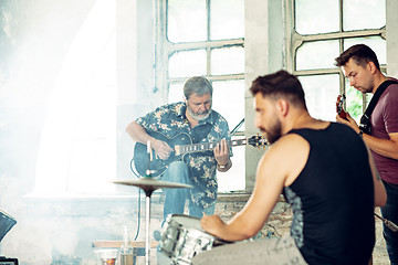 Image showing Repetition of rock music band. Electric guitar player and drummer behind the drum set.