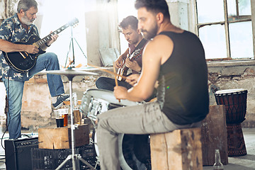 Image showing Repetition of rock music band. Electric guitar player and drummer behind the drum set.