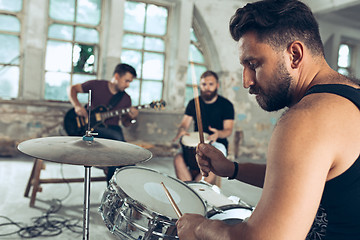 Image showing Repetition of rock music band. Electric guitar player and drummer behind the drum set.