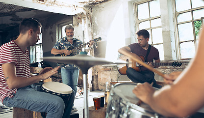 Image showing Repetition of rock music band. Electric guitar player and drummer behind the drum set.