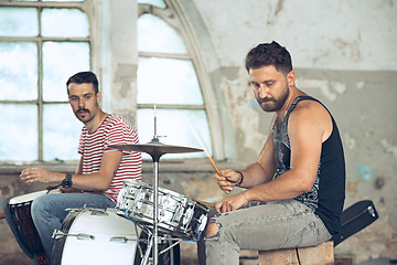 Image showing Repetition of rock music band. Electric guitar player and drummer behind the drum set.