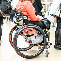 Image showing Close up of unrecognizable hanicapped woman on a wheelchair queuing in line to perform everyday tasks.