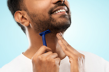 Image showing close up of man shaving beard with razor blade