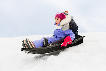 Image showing little kids sliding on sled down hill in winter