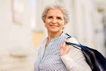 Image showing senior woman with shopping bags on city street