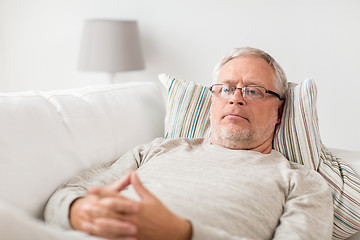 Image showing senior man  lying on sofa and thinking at home