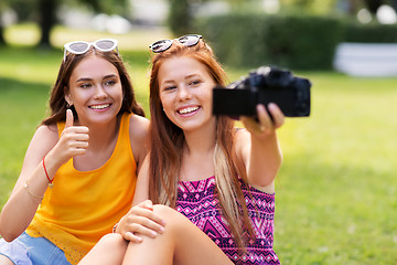 Image showing teenage bloggers recording video by camera in park